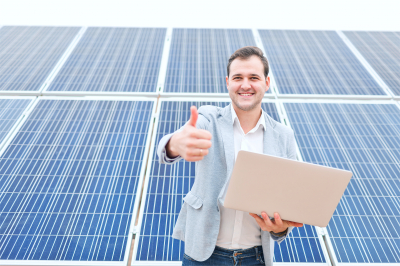 man standing against a background of solar panels